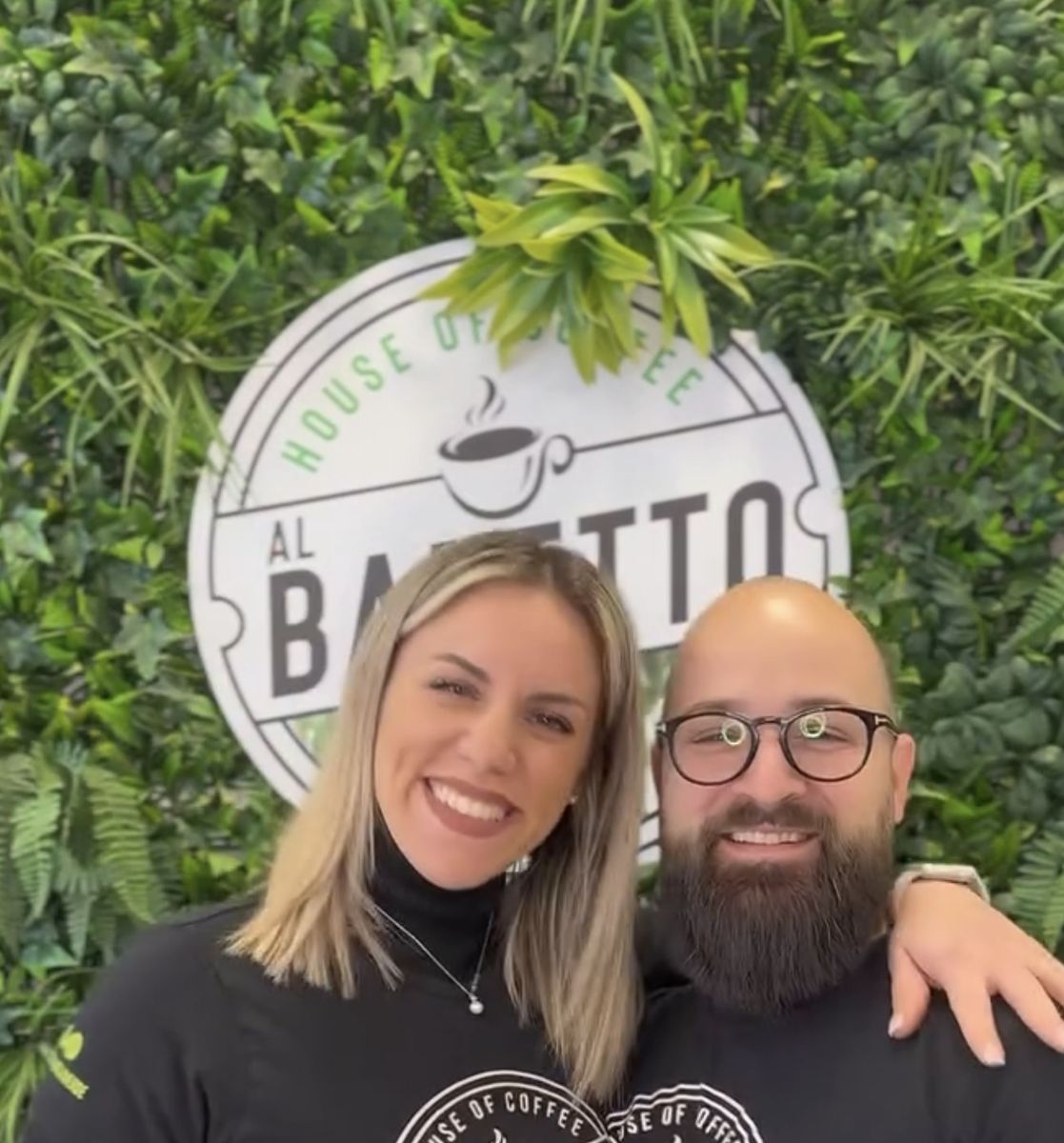 Antonio e Martina davanti al muro verde con il logo Al Baretto